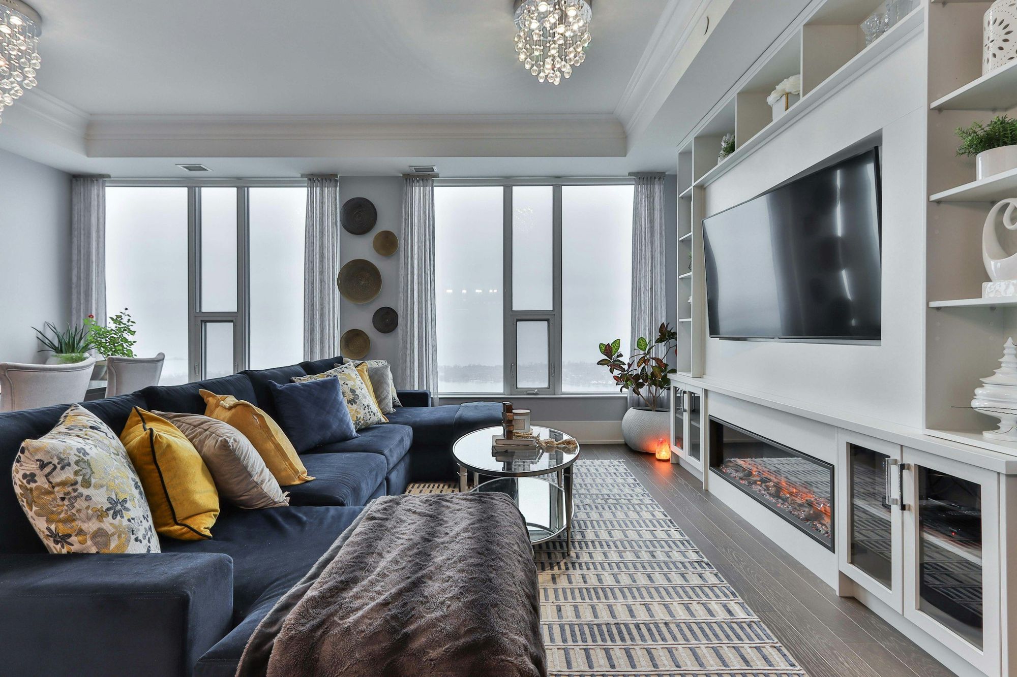 A white built-in media wall with a linear fireplace and open shelving